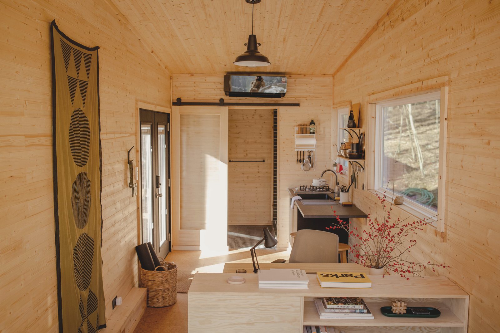 The full length of the interior, pine-lined, with the kitchen at the far end